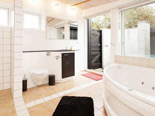 uma casa de banho com uma banheira, um WC e um lavatório. em 6 person holiday home in Dronningm lle em Dronningmølle