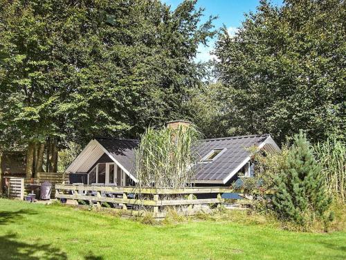 een huis in een veld met een hek en bomen bij 6 person holiday home in Toftlund in Arrild