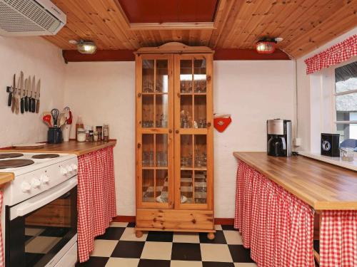 una cocina con un armario de madera lleno de copas de vino en 12 person holiday home in L s en Læsø