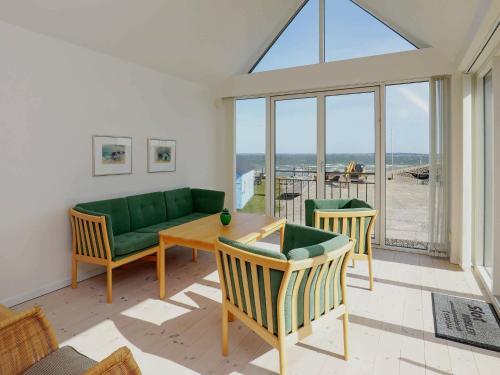 Thyholmにある6 person holiday home in Thyholmのリビングルーム(緑のソファ、椅子付)