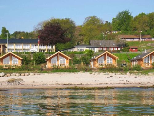 una fila di case su una spiaggia vicino all'acqua di 6 person holiday home in Allinge ad Allinge