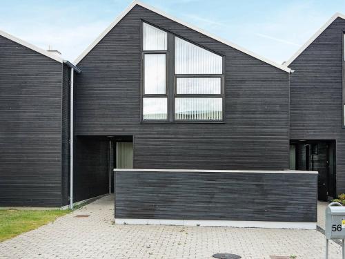 Øster Hurupにある8 person holiday home in Hadsundの大きな窓のある黒い家