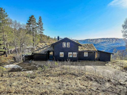 a large black house on top of a hill at 10 person holiday home in SERAL in Åseral