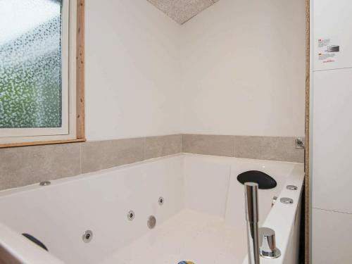 a bath tub in a bathroom with a window at 5 person holiday home in Knebel in Knebel