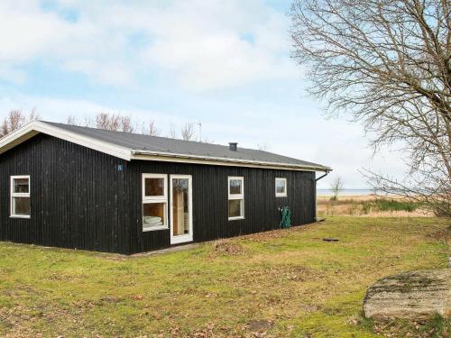 Ørstedにある10 person holiday home in rstedの草原白窓のある黒家