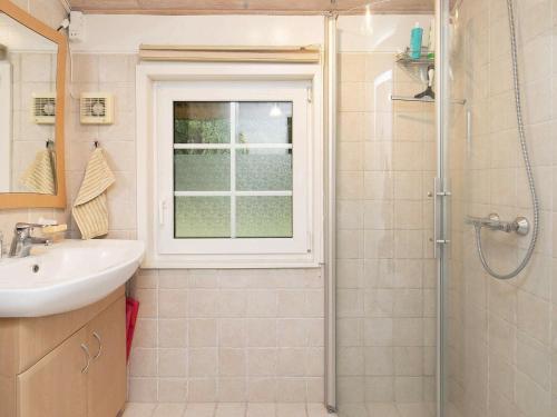 ein Bad mit einem Waschbecken und einer Dusche mit einem Fenster in der Unterkunft Holiday home Ulfborg XXIII in Ulfborg