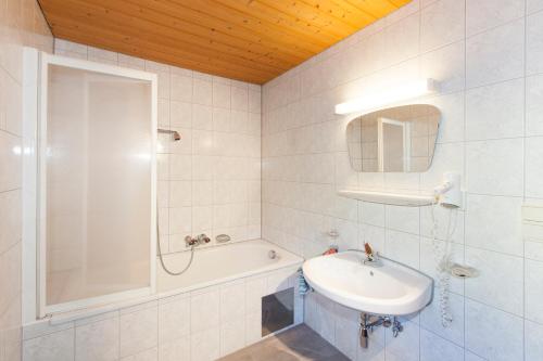 uma casa de banho branca com um lavatório e um chuveiro em Landhaus Grüner em Sölden