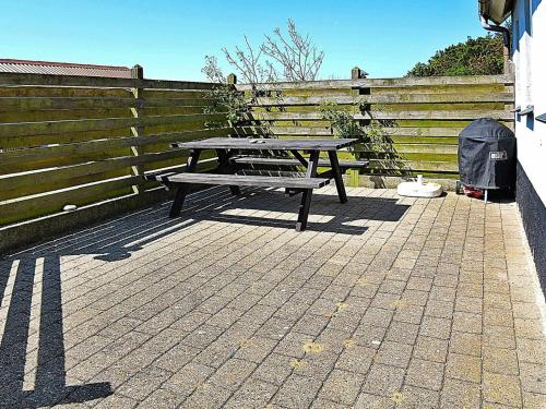 una mesa de picnic en un patio junto a una valla en 6 person holiday home in Hvide Sande, en Hvide Sande