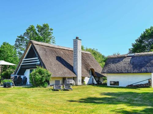 uma casa antiga com um telhado de palha num campo em 6 person holiday home in Asperup em Asperup