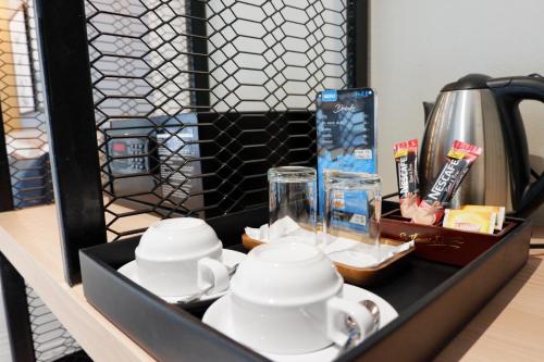 a tray with cups and teapots on a table at Chill D Resort Buriram in Buriram