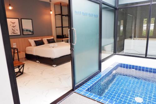 1 dormitorio y baño con piscina. en Chill D Resort Buriram, en Buriram