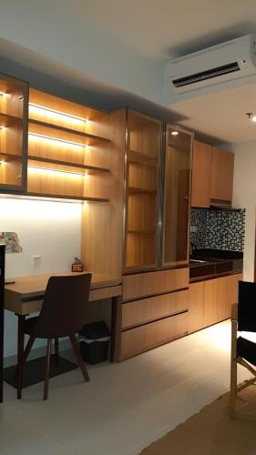 een keuken met houten kasten en een tafel met stoelen bij Studio Suite Roseville @ BSD City, Great Location in Tangerang