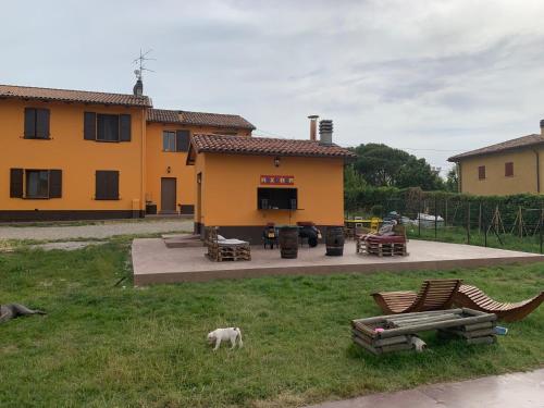 una casa amarilla con un perro parado en el patio en Casa Particular, en Castel San Pietro Terme