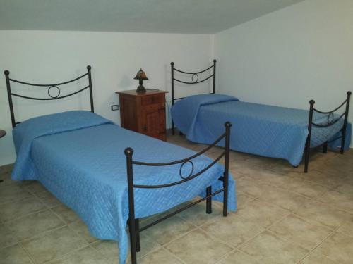 een slaapkamer met 2 bedden en een houten dressoir bij B&B Perdalonga in Ghilarza