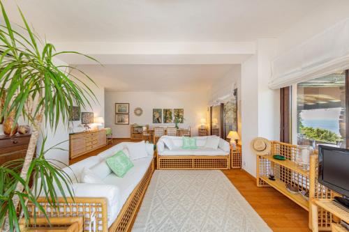 Una sala de estar con un sofá y un televisor. en Villa Romantica, en Olbia