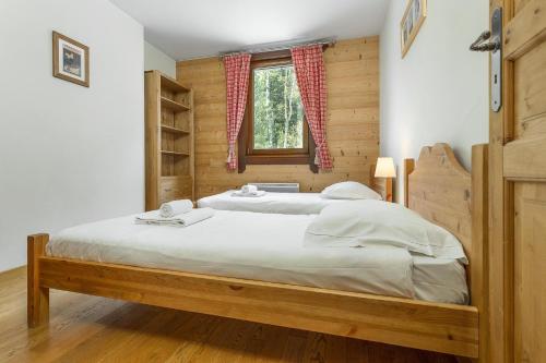 1 dormitorio con 1 cama grande con marco de madera en APARTMENT STADDON - Alpes Travel - Central Chamonix - Sleeps 4-6, en Chamonix-Mont-Blanc