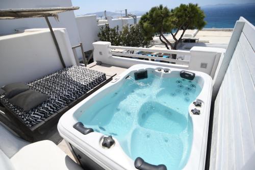 a jacuzzi tub on top of a balcony at Flaskos Suites and more in Agios Stefanos