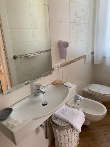 a bathroom with a sink and a toilet and a mirror at Agriturismo La Pietra in La Spezia
