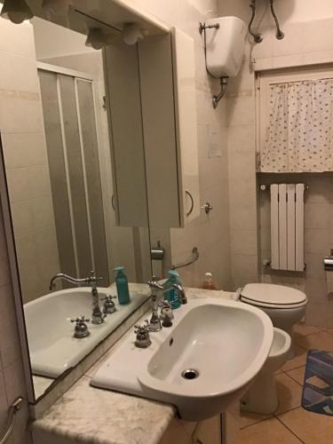 bagno con lavandino, servizi igienici e specchio di Achirina bed and breakfast a Cisterna di Latina