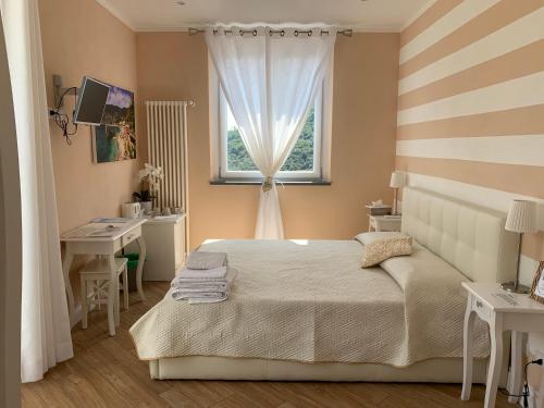 a bedroom with a bed and a window and a desk at Agriturismo La Pietra 1 e La Pietra 2 in La Spezia
