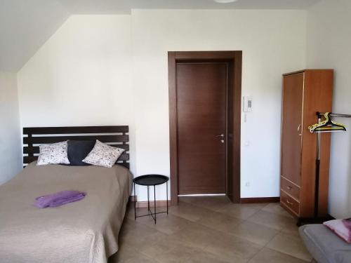 um quarto com uma cama e uma porta de madeira em Дом напротив отеля "Рамада Энкор" em Kiev