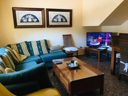 uma sala de estar com um sofá azul e uma televisão em Las Eras em Talveila