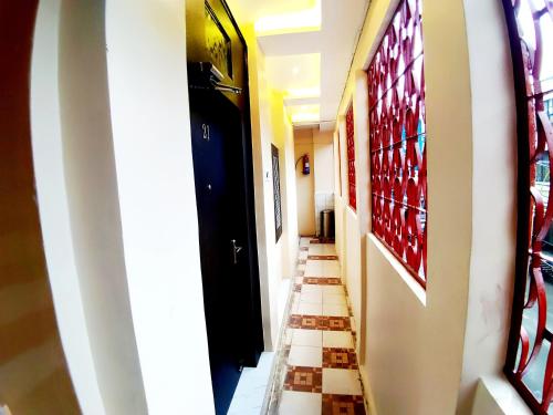 a hallway with tile floors and stained glass windows at City Hotel in Allahābād