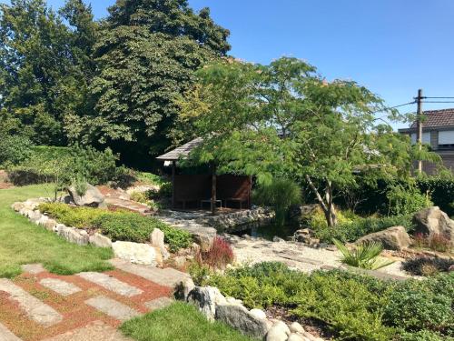 a garden with a small cabin in the background at B&B Tolkantoor in Zelzate