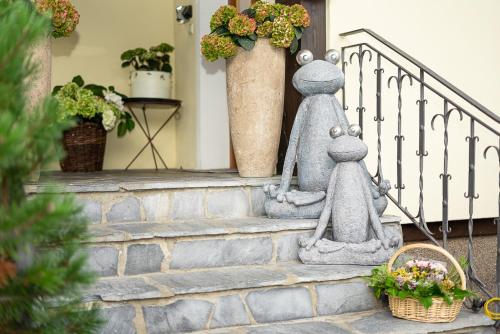 two statues of dogs sitting on the steps of a house at Das Landhaus in Gerlos