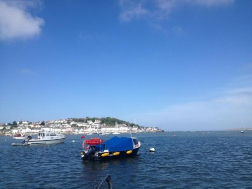 a small boat with a blue cover in the water at The Commodore Hotel in Instow