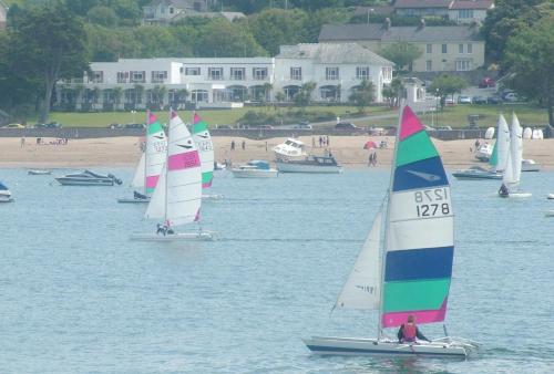 a group of sailboats in the water near a beach at The Commodore Hotel in Instow