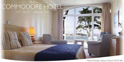 een hotelkamer met een bed en een groot raam bij The Commodore Hotel in Instow
