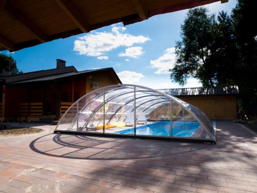 a glass igloo with a swimming pool in it at Radawa - Domki przy Stadninie in Radawa