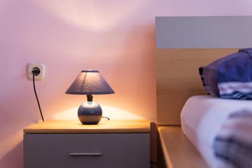 a lamp on a night stand next to a bed at Apartment Marita in Senj