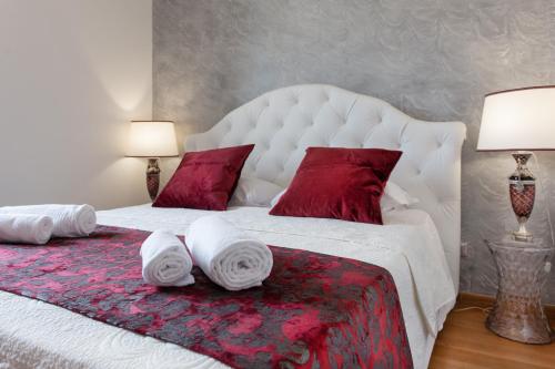 a bedroom with a large white bed with red pillows at Residenza Duomo3 - Apartments in Verona