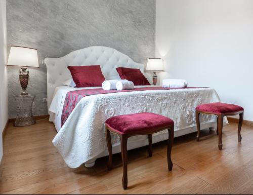 a bedroom with a large white bed with two chairs at Residenza Duomo3 - Apartments in Verona