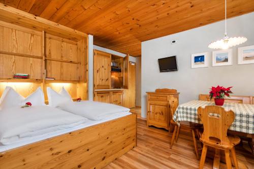 een slaapkamer met een groot bed en een tafel bij Apartments Antares in Colfosco