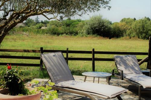 two chairs and a table in front of a fence at Mas Fandelou in Saintes-Maries-de-la-Mer