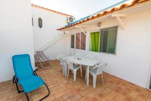 a patio with a white table and chairs at Casas Algarvias in Arroteia de Baixo