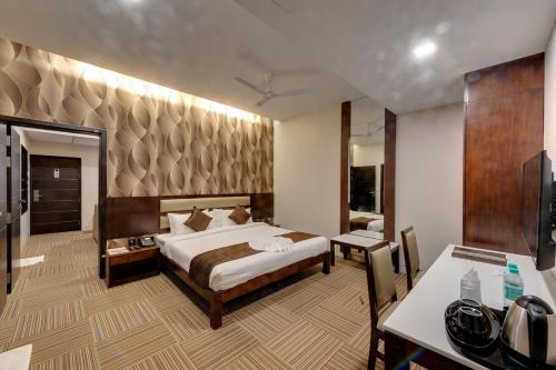 um quarto de hotel com uma cama e uma casa de banho em Hotel Ma Grand em Pudukkottai