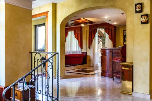 a living room with a staircase and a red couch at Hotel Villa Venus Resort & SPA in Atena Lucana