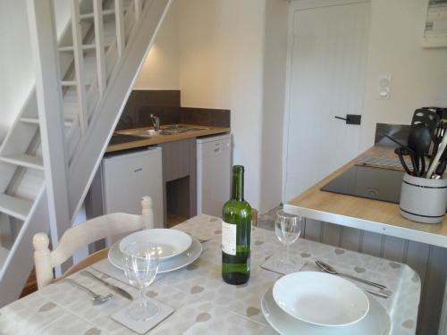 a table with two plates and a bottle of wine at La Petite Tour in Carlux