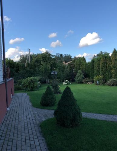 a garden with two trees on a lawn at Arvydo Gylio sodyba in Ignalina