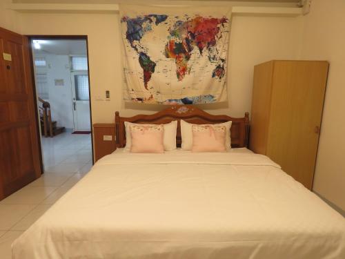 a bedroom with a large bed with a map on the wall at Sunny House II in Guilin