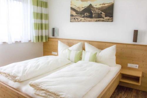ヒパッハにあるApart Alpinのベッド(白いシーツ、枕付)