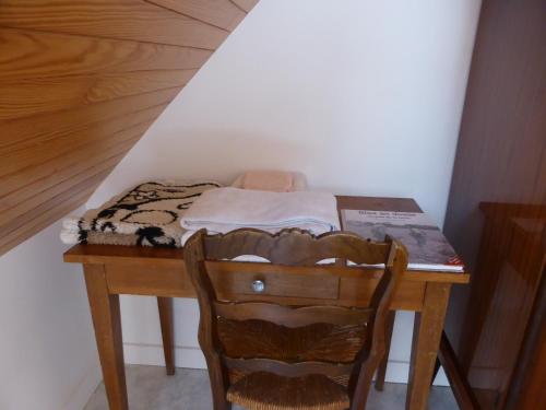 a wooden table with a bed and a chair at ty dreux entre terre et mer in Saint-Thégonnec