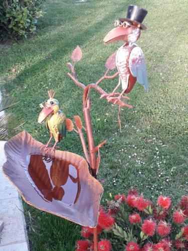 a statue of a bird on a tree with a mirror at Gîte La MER in Commes