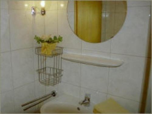 ein Bad mit einem Waschbecken und einem Spiegel in der Unterkunft Haus Deichblick in Husum