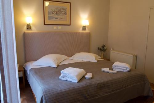 a bedroom with a bed with towels on it at Esperia Boutique Hotel in Agrinion