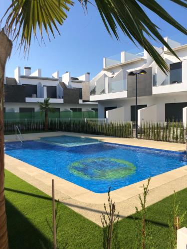 a swimming pool in front of a house at Modern Studio Lamar Resort in Pilar de la Horadada